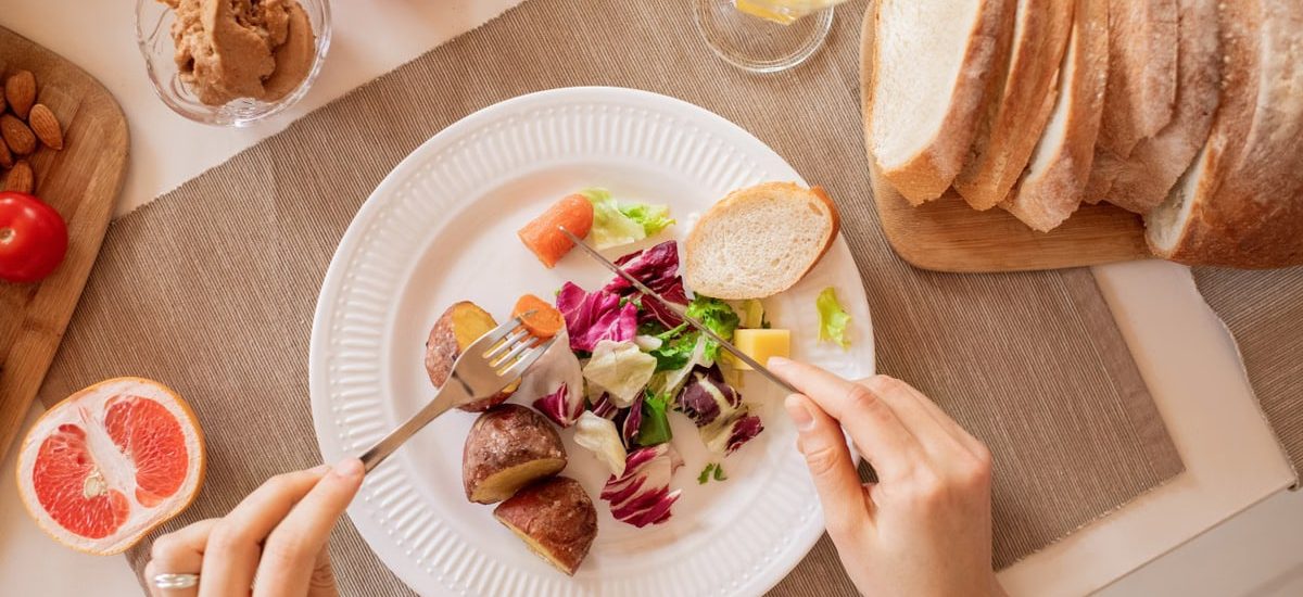 Top view of a nutritious breakfast setup with salad, bread, and fresh juice, perfect for a healthy start.
