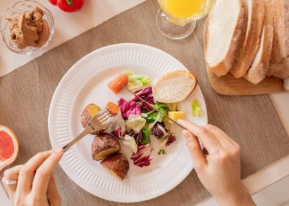 Top view of a nutritious breakfast setup with salad, bread, and fresh juice, perfect for a healthy start.