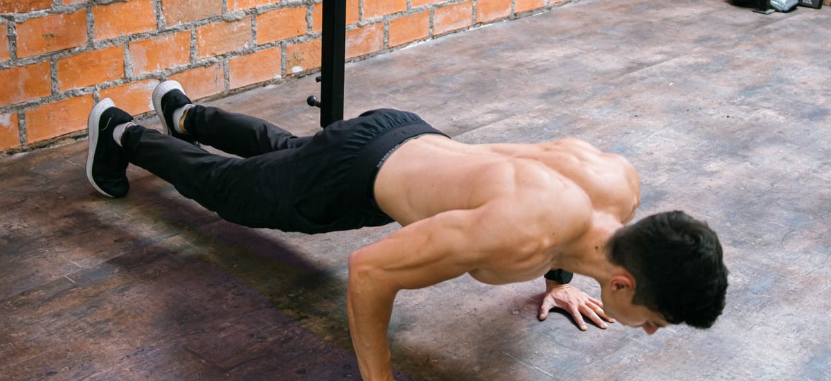 A fit man performs push-ups in a Ciudad de México gym, showcasing strength and dedication.