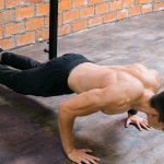 A fit man performs push-ups in a Ciudad de México gym, showcasing strength and dedication.